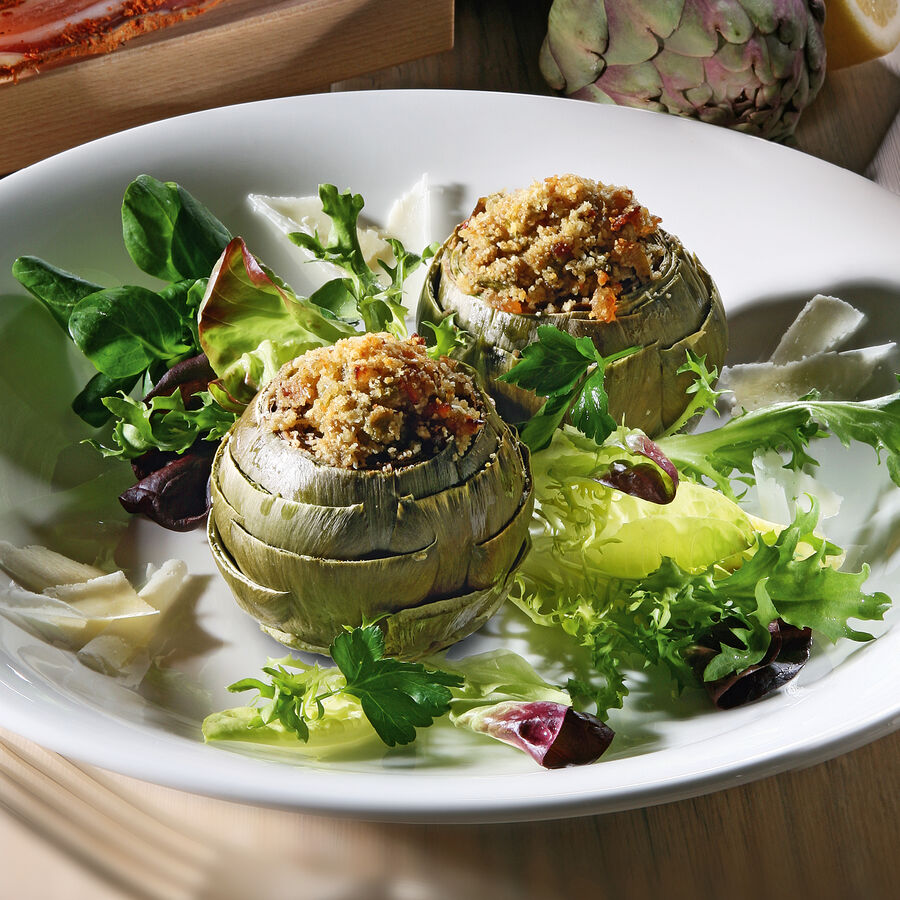 Gefllte Artischocken mit Pancetta auf buntem Blattsalat