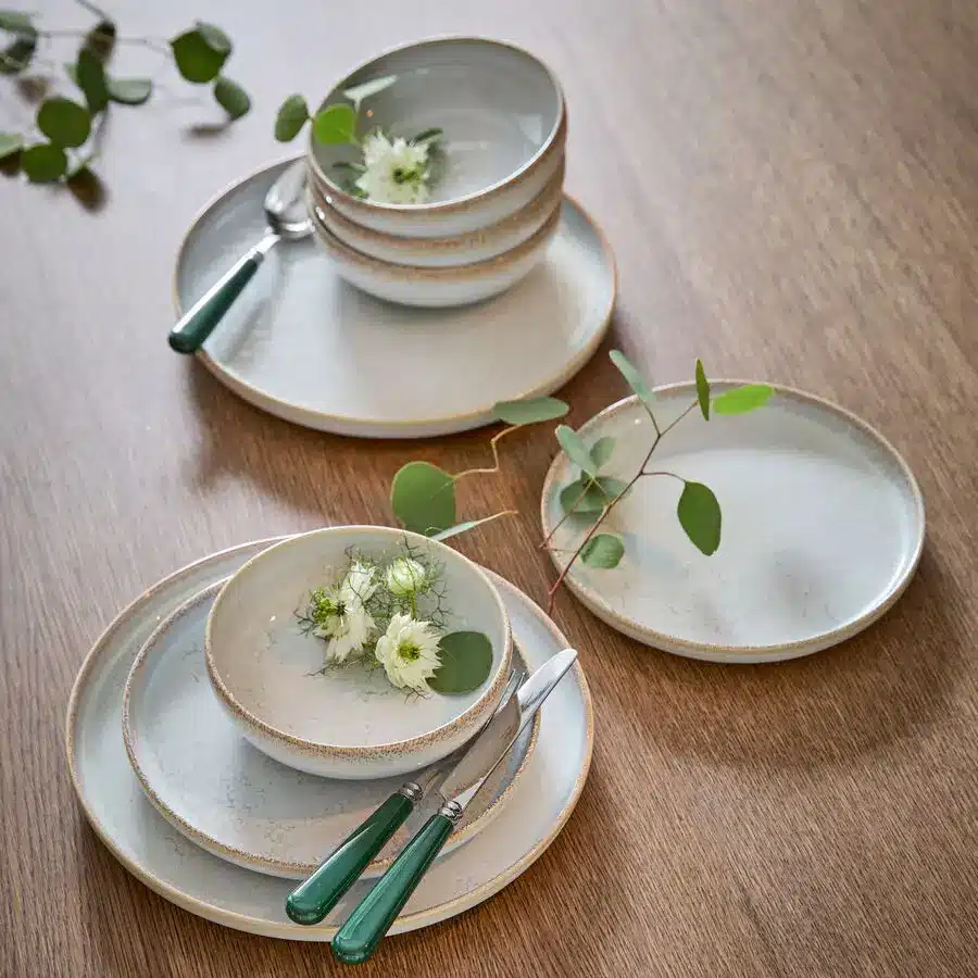 Modernes Geschirr-Set aus Steingut mit grünen Besteckgriffen und Blumen-Deko