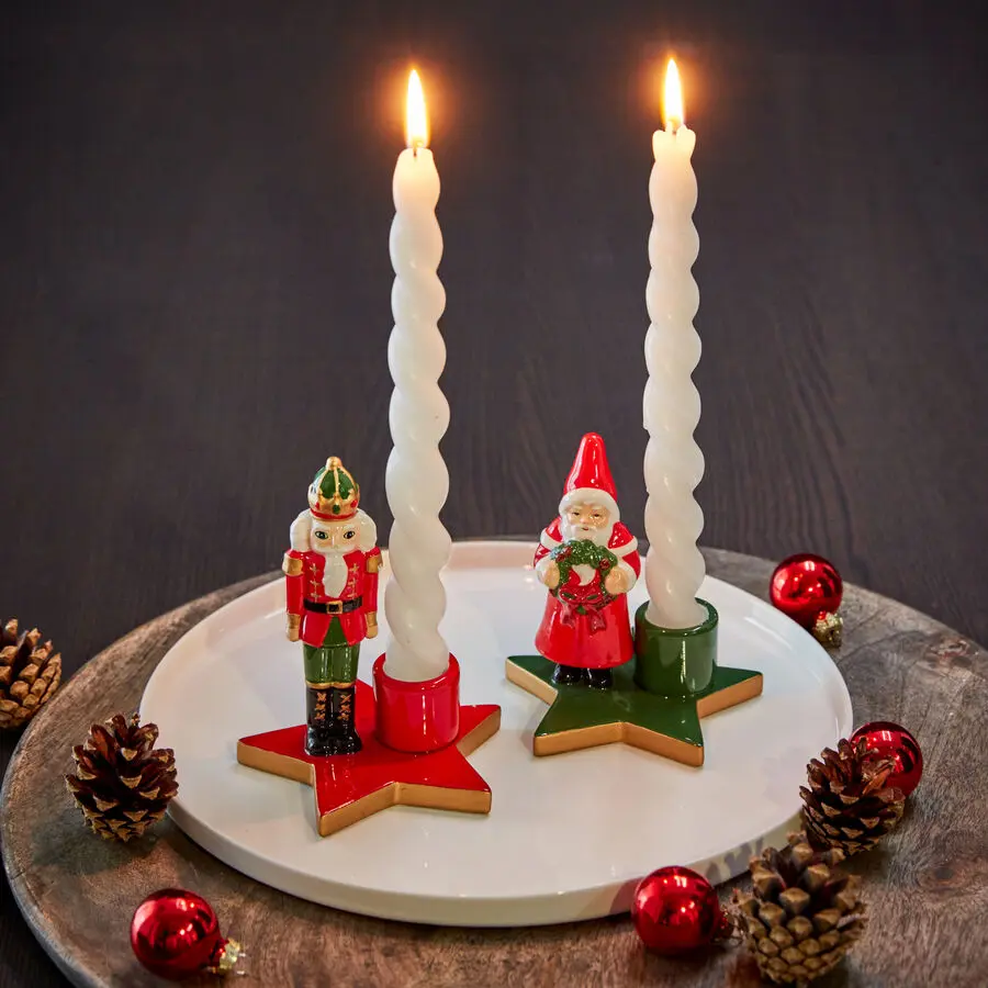 Festliche Kerzenhalter mit Nussknacker und Weihnachtsmann, weiße Spiral-Kerzen auf roten und grünen Sternsockeln