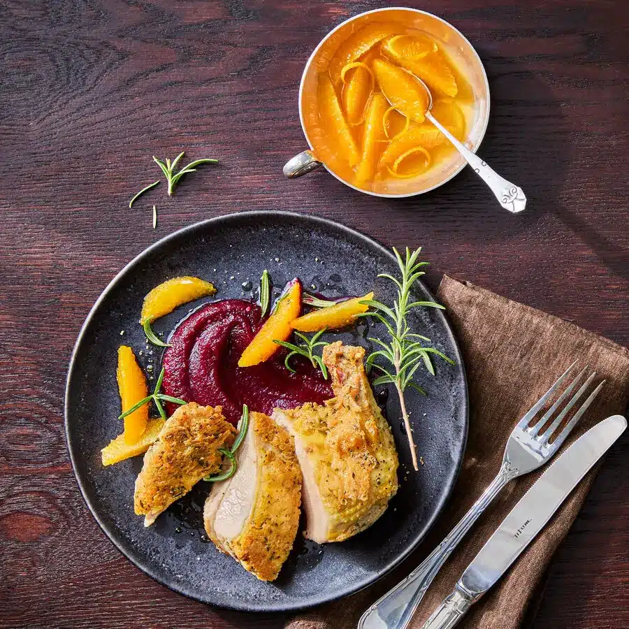 Französische Perlhuhnbrust, zart gegart, serviert mit Kräutern und fruchtiger Sauce