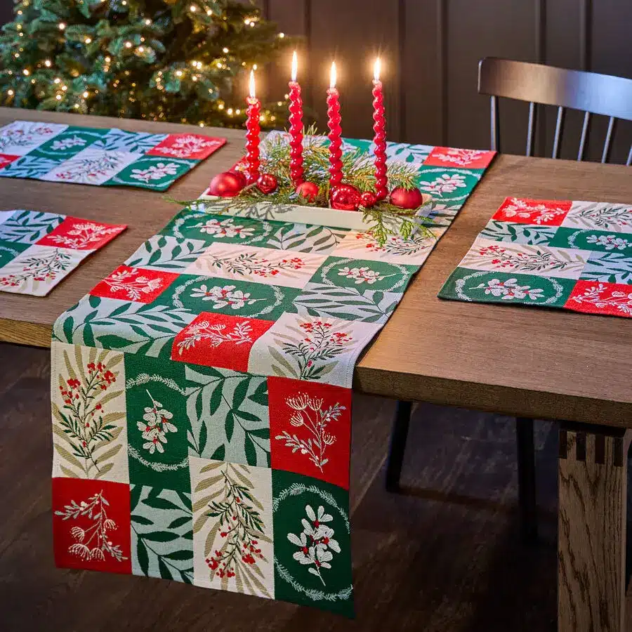 Weihnachtstisch mit bunt gemustertem Weihnachtstischläufer in Rot und Grün, Kerzen als Deko