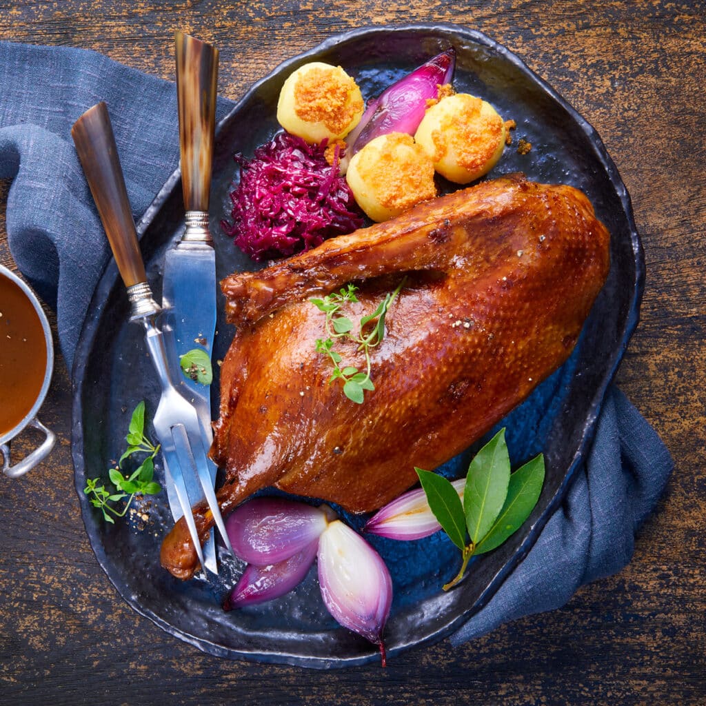 Klassische Weihnachtsgans mit Knödeln, Rotkohl und Zwiebeln – knusprig gebraten, festlich serviert