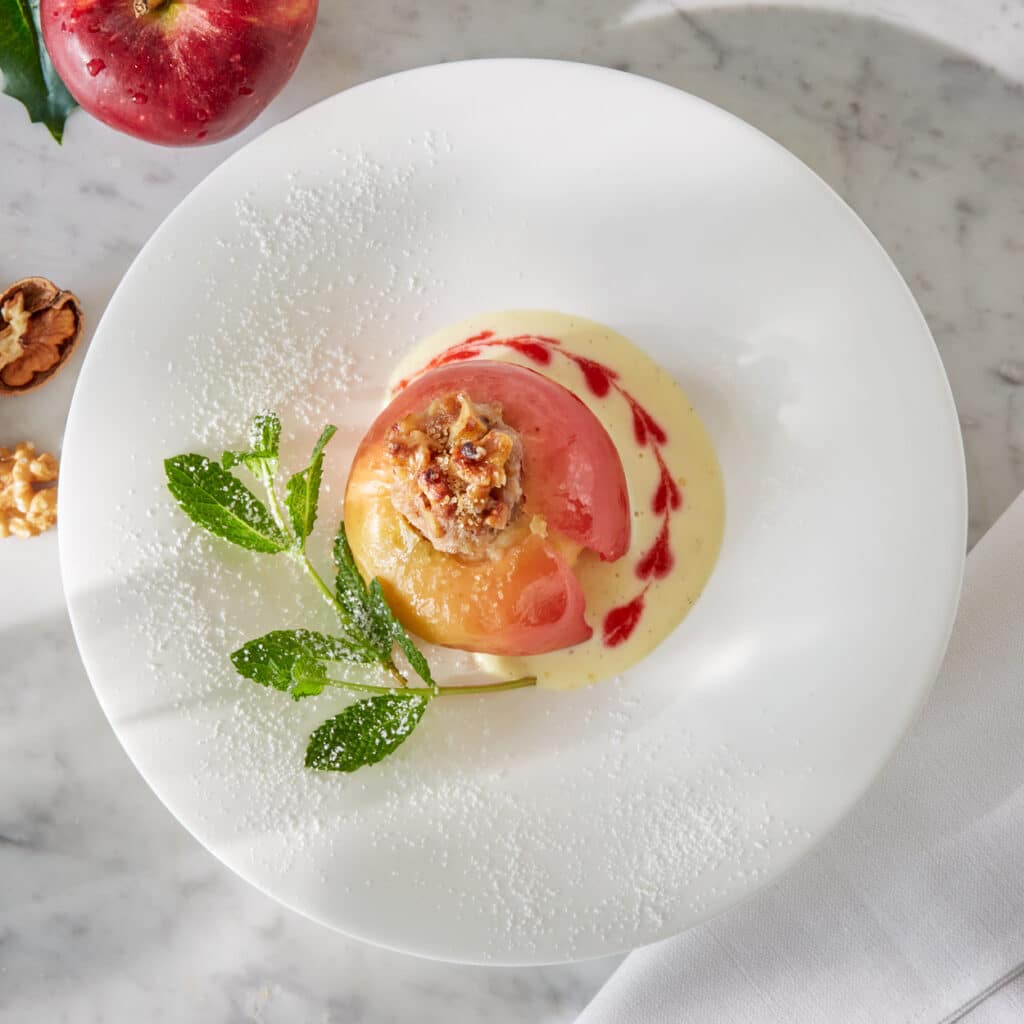 Gefüllter Bratapfel mit Walnüssen, Himbeerspiegel und weihnachtlichen Aromen.