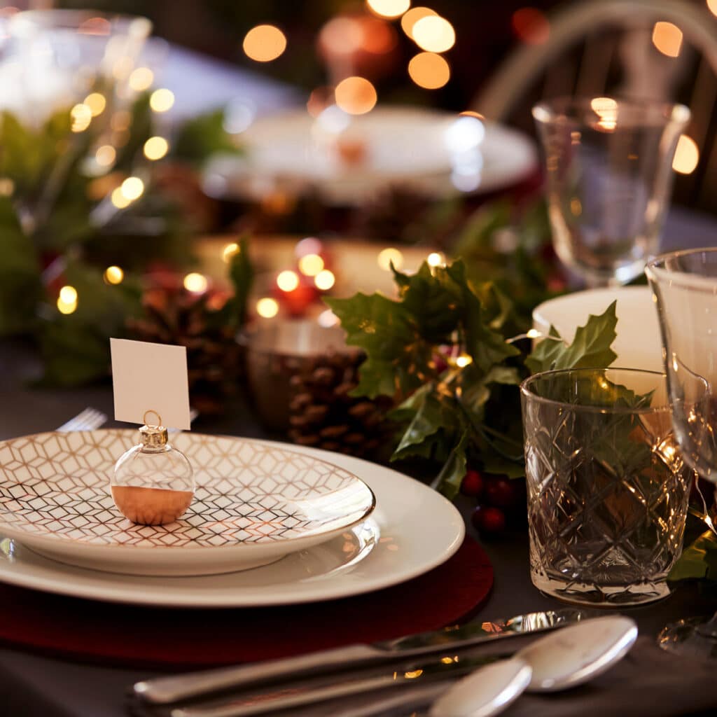Festlich gedeckter Weihnachtstisch mit Lichterketten, Kristallgläsern und Dekoration