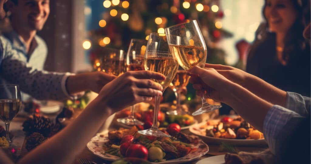 Freunde heben Gläser beim Weihnachtsessen – festliche Stimmung mit Lichtern und Dekoration