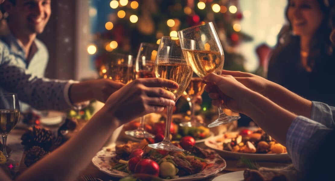 Freunde heben Gläser beim Weihnachtsessen – festliche Stimmung mit Lichtern und Dekoration