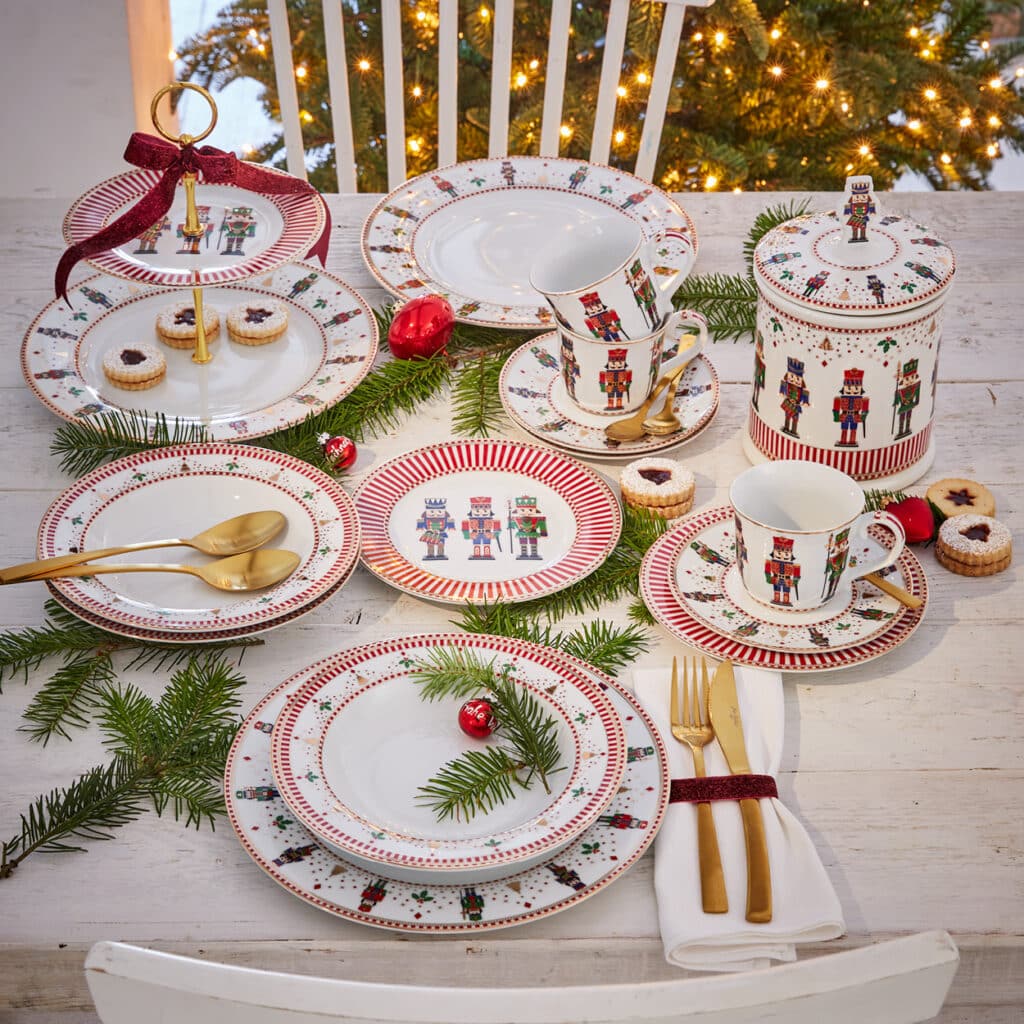 Festliches Weihnachtsgeschirr mit Nussknacker-Motiven, dekoriert mit Tannenzweigen