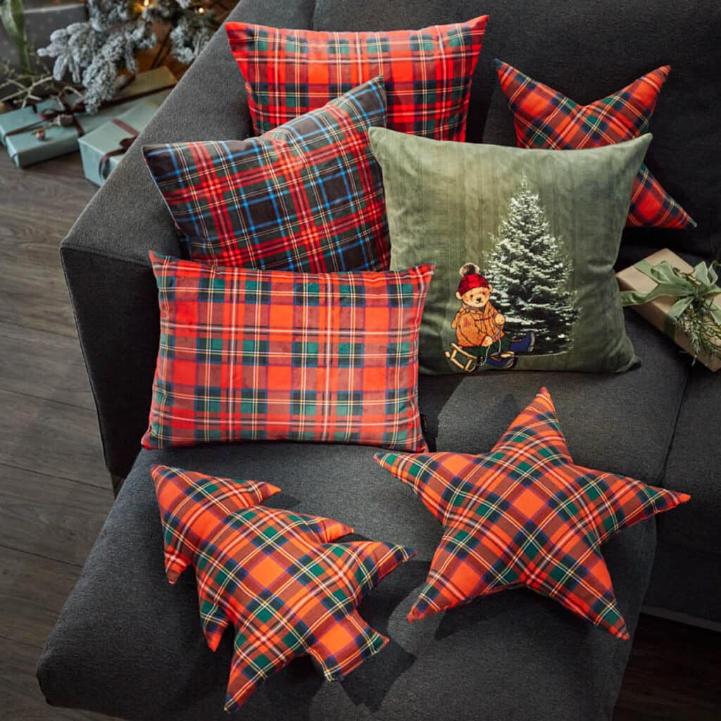 Sofa mit karierten Weihnachtskissen und Kissen in Stern- und Tannenbaumform