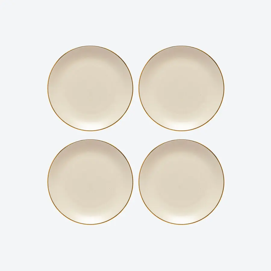 Vier cremefarbene Teller mit feinem Goldrand, schlicht und elegant arrangiert