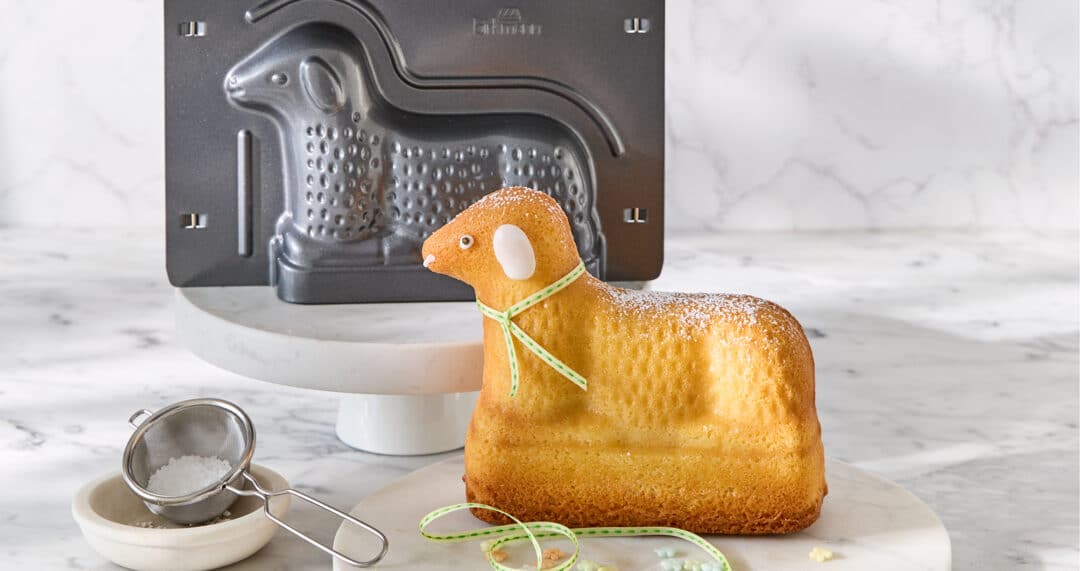 Osterlamm in Motivform gebacken, daneben Osterlamm-Backform und Sieb zum Best&auml;uben