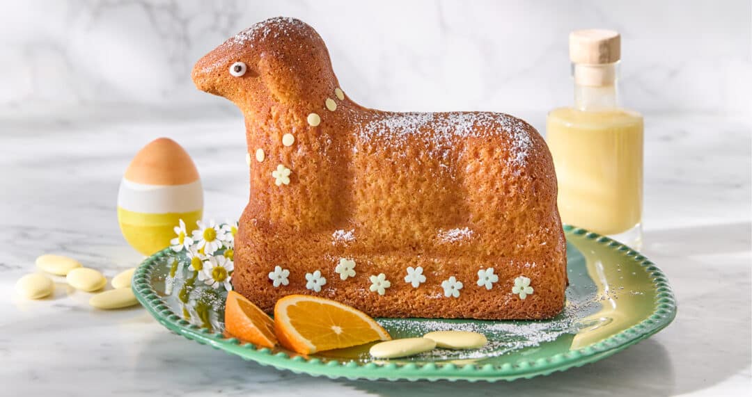 Eierlik&ouml;r-Osterlamm mit feiner Dekoration, serviert mit Eierlik&ouml;r im Hintergrund