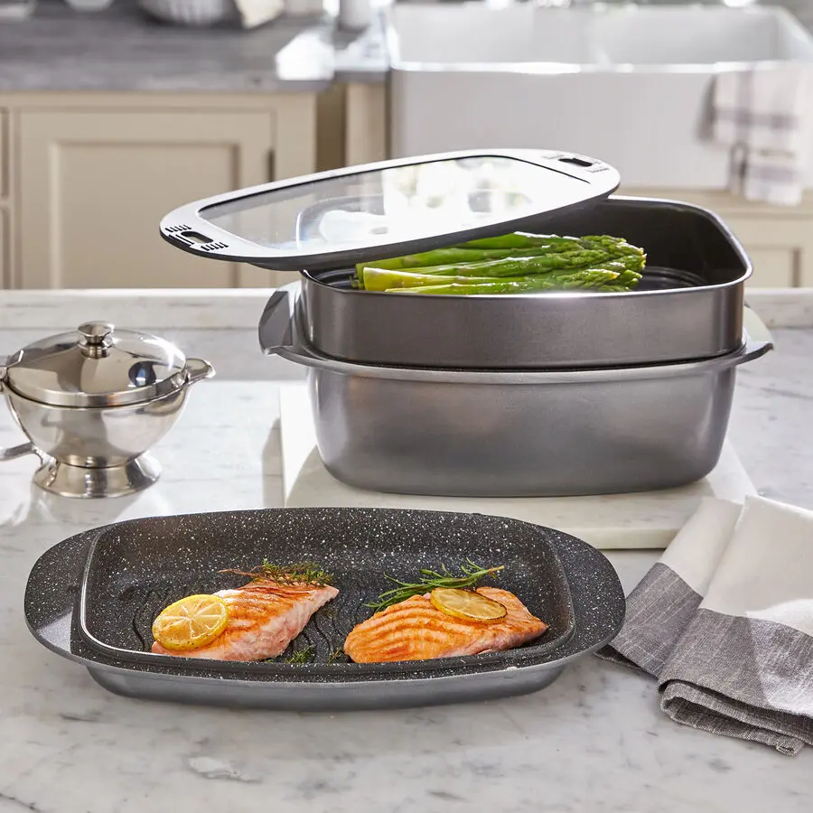 Multifunktionales Br&auml;ter- und Kochset mit Dampfeinsatz f&uuml;r gr&uuml;nen Spargel, im Vordergrund Grillplatte mit Lachsfilets